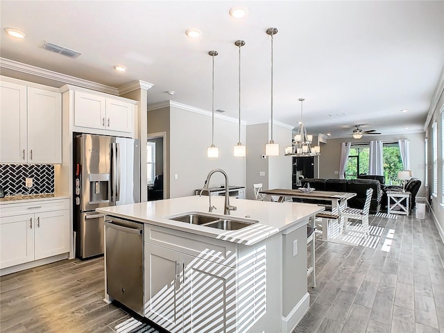 kitchen featuring appliances with stainless steel finishes, an island with sink, white cabinetry, and sink