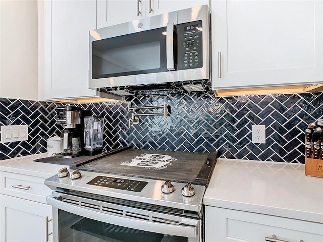 kitchen with white cabinets, decorative backsplash, and appliances with stainless steel finishes