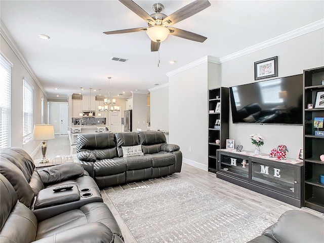 living room with ceiling fan with notable chandelier, hardwood / wood-style flooring, and ornamental molding