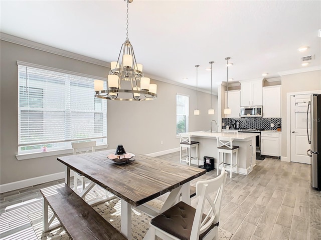 dining area with light hardwood / wood-style floors, a wealth of natural light, and a notable chandelier