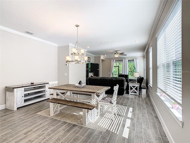 dining area with crown molding, ceiling fan with notable chandelier, and hardwood / wood-style flooring