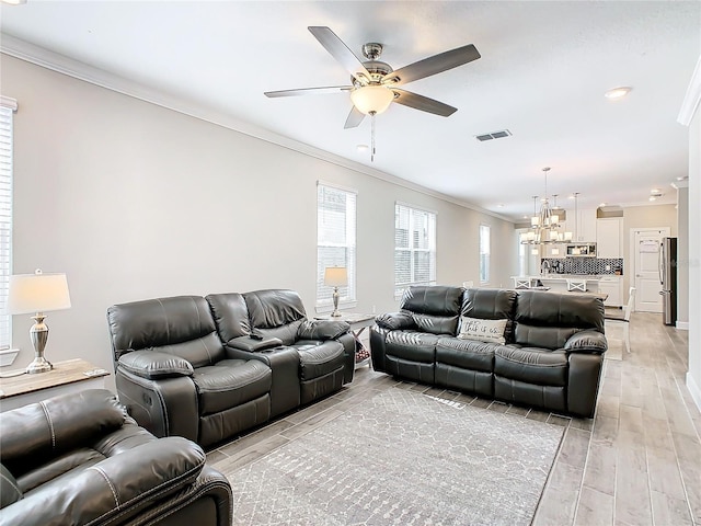 living room featuring crown molding, light hardwood / wood-style flooring, and ceiling fan