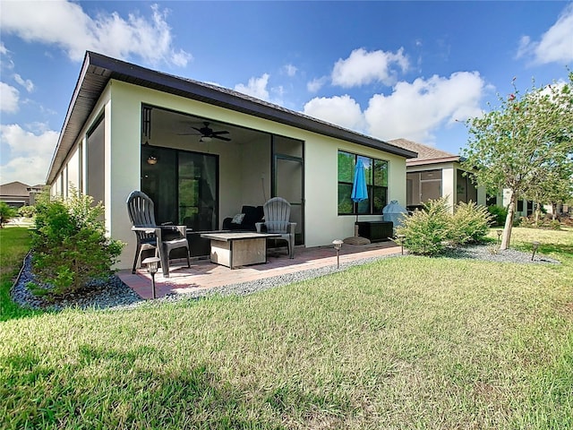 rear view of house featuring outdoor lounge area, ceiling fan, a yard, and a patio