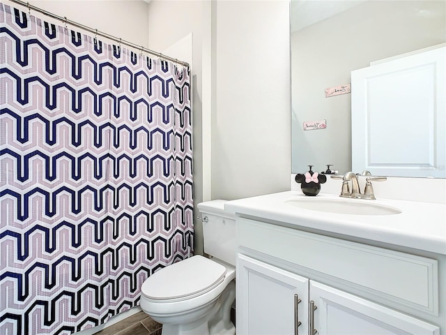 bathroom featuring walk in shower, vanity, wood-type flooring, and toilet