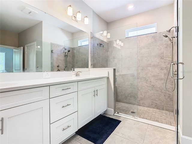 bathroom featuring tile patterned flooring, vanity, and an enclosed shower