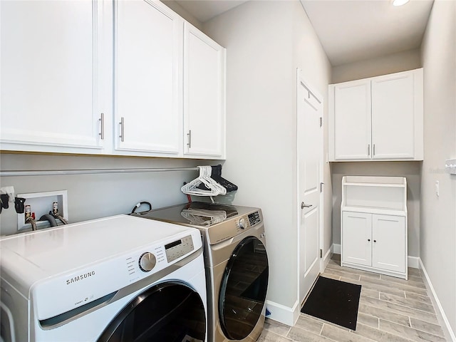 clothes washing area with independent washer and dryer, cabinets, and light wood-type flooring