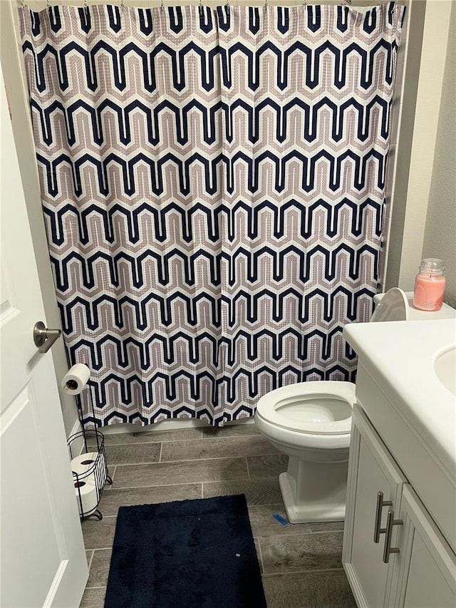 bathroom featuring a shower with curtain, vanity, toilet, and hardwood / wood-style floors