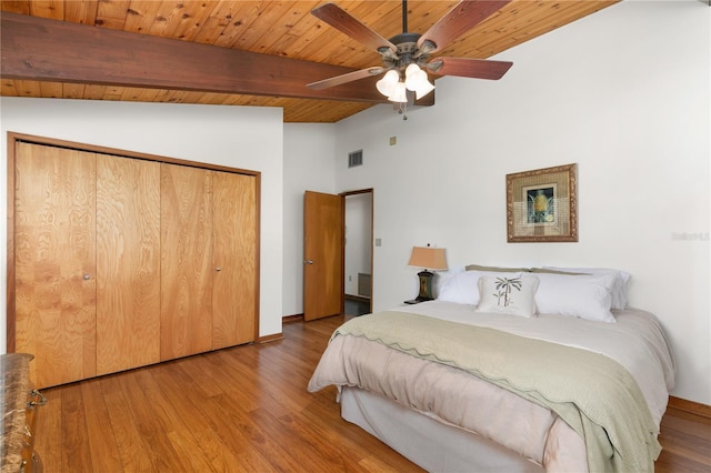 unfurnished bedroom featuring wooden ceiling, lofted ceiling with beams, wood-type flooring, and a closet