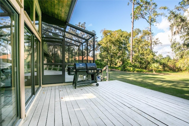 deck with glass enclosure, area for grilling, and a yard