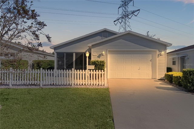 single story home with a garage and a lawn