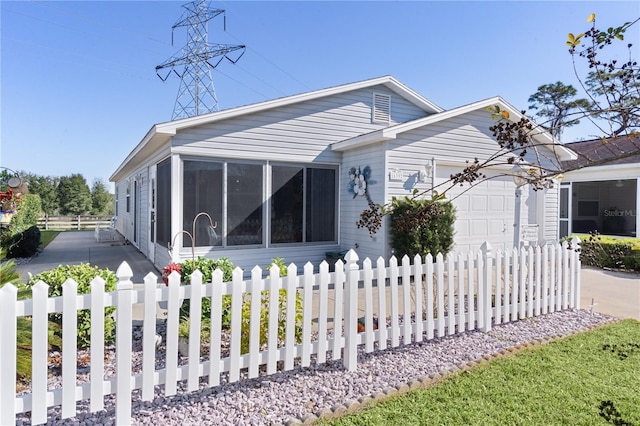 view of front of home with a sunroom and a garage