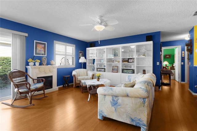 living room with a healthy amount of sunlight, a textured ceiling, and wood-type flooring