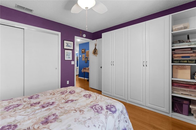 bedroom featuring a textured ceiling, light wood-type flooring, and ceiling fan