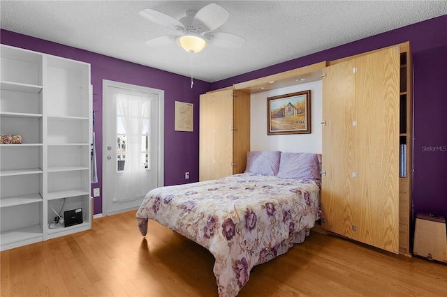 bedroom featuring hardwood / wood-style floors, a textured ceiling, and ceiling fan