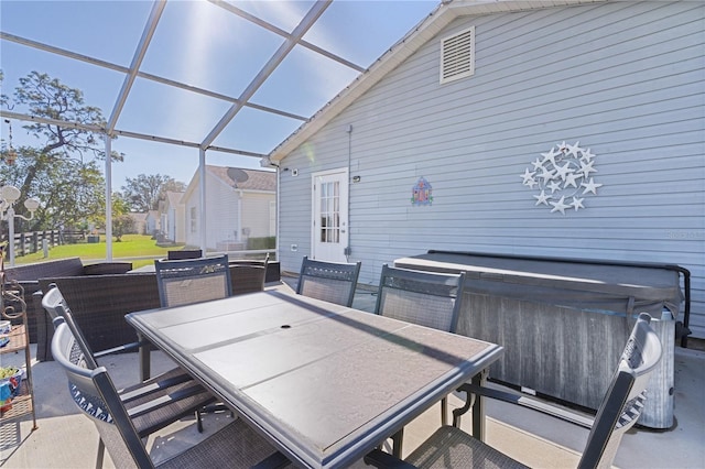 view of patio with glass enclosure and a hot tub