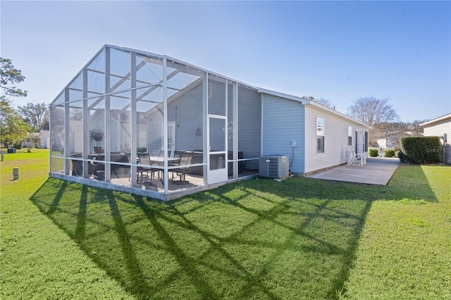 back of property featuring a yard, glass enclosure, central AC, and a patio area