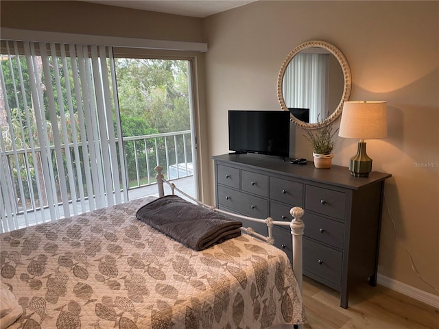 bedroom with light wood-type flooring and access to outside