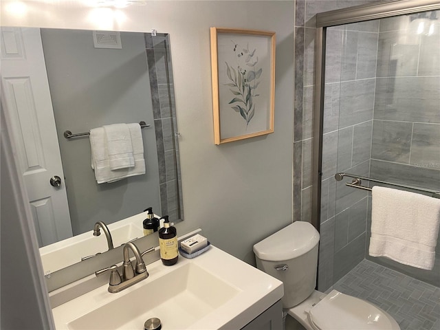 bathroom featuring vanity, toilet, and walk in shower