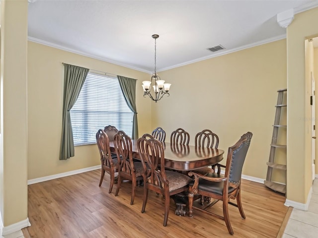 dining room with light hardwood / wood-style flooring, a notable chandelier, and ornamental molding