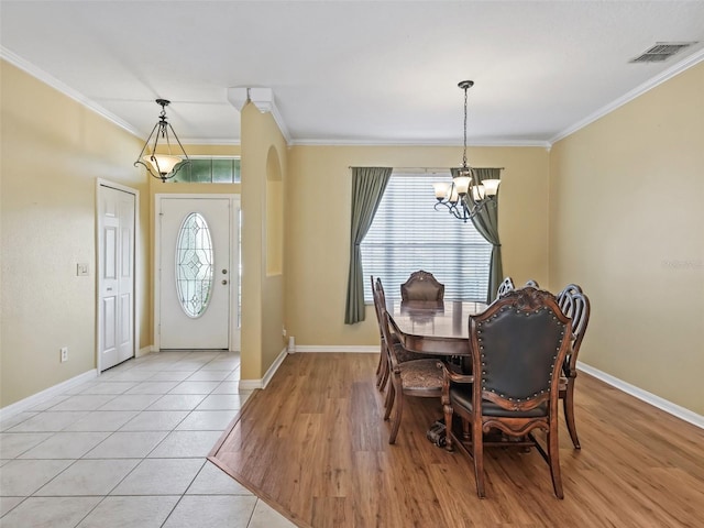 dining space with a healthy amount of sunlight, crown molding, and light hardwood / wood-style flooring