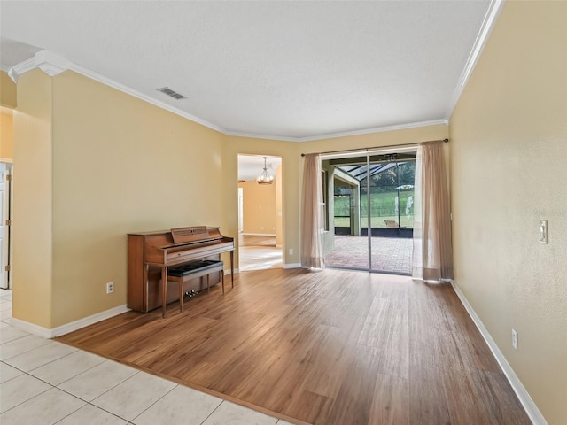 interior space with light wood-type flooring, crown molding, and an inviting chandelier