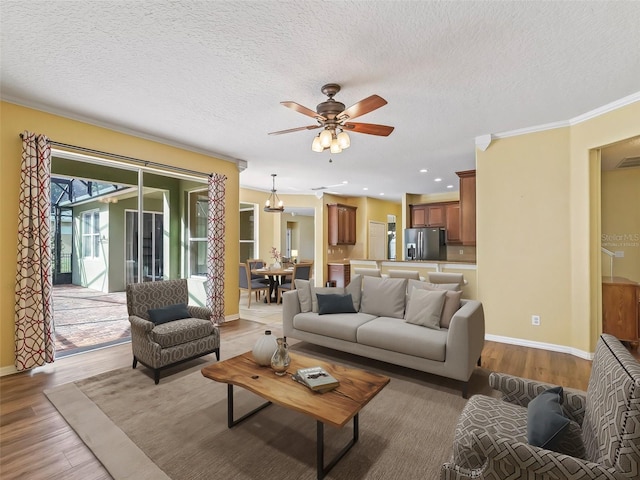 living room featuring crown molding, a textured ceiling, and light wood-type flooring