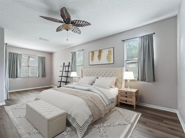 bedroom featuring ceiling fan, dark wood-type flooring, and a textured ceiling