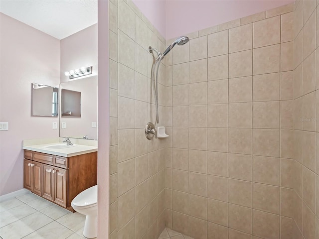 bathroom featuring tile patterned floors, vanity, toilet, and a tile shower