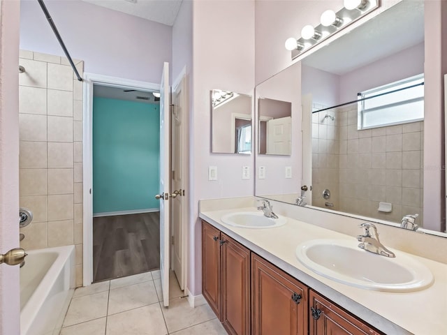 bathroom featuring tile patterned flooring, vanity, and tiled shower / bath