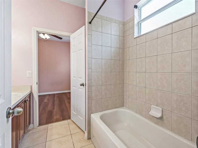 bathroom with tile patterned flooring, vanity, tiled shower / bath, and ceiling fan