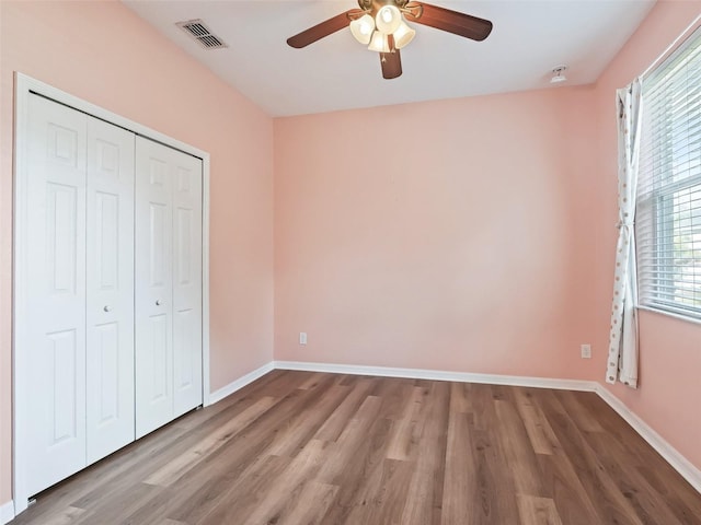 unfurnished bedroom featuring ceiling fan, a closet, and light hardwood / wood-style floors