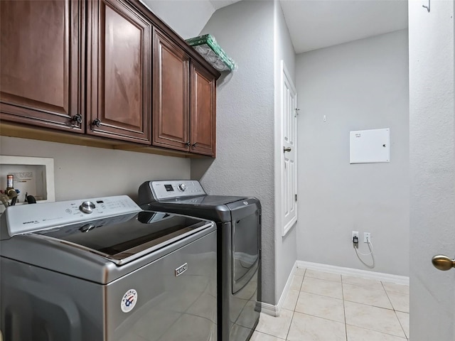 laundry room featuring cabinets, separate washer and dryer, and light tile patterned floors