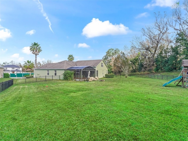 view of yard with a lanai and a playground