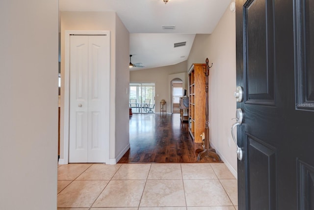 tiled entryway featuring ceiling fan and lofted ceiling