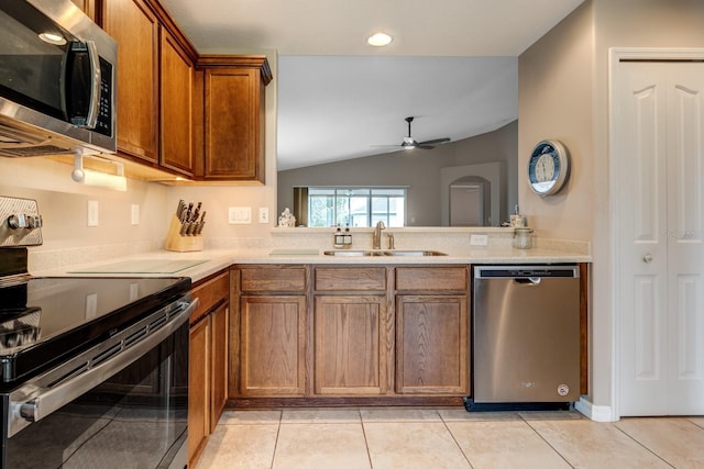 kitchen featuring ceiling fan, sink, stainless steel appliances, lofted ceiling, and light tile patterned floors