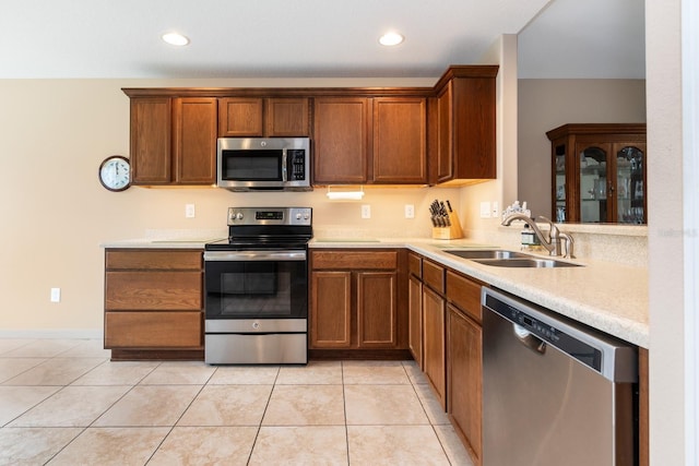 kitchen featuring appliances with stainless steel finishes, light tile patterned floors, and sink