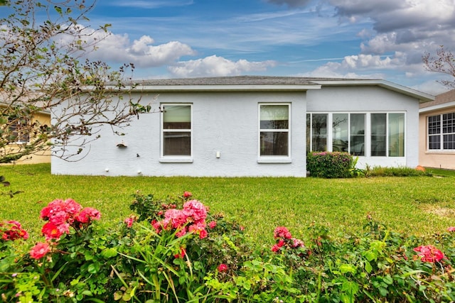 rear view of property featuring a lawn