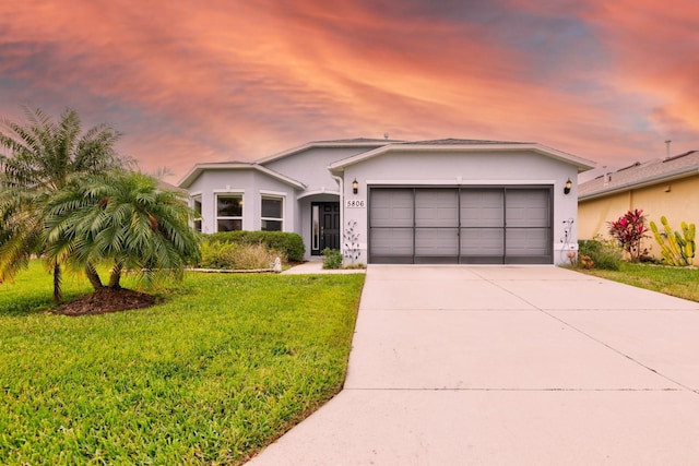 ranch-style house featuring a lawn and a garage