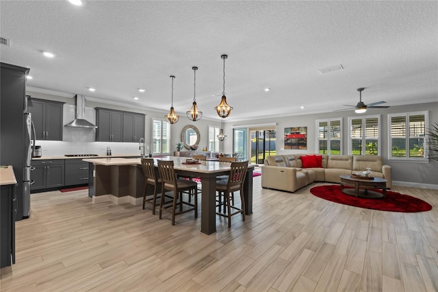 dining space featuring crown molding, plenty of natural light, ceiling fan, and light hardwood / wood-style flooring