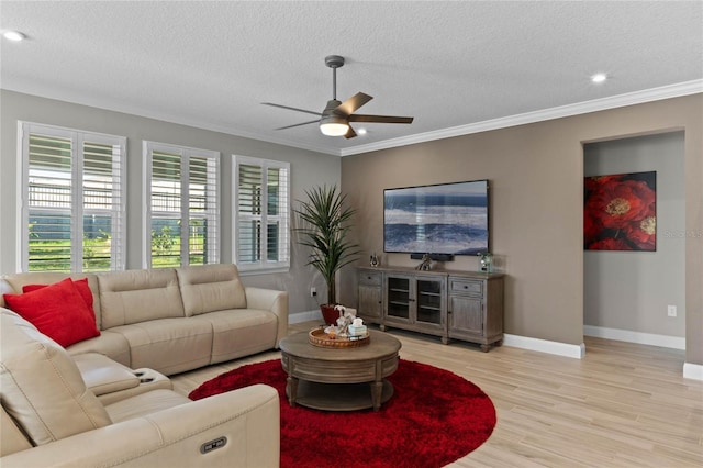 living room featuring a textured ceiling, light hardwood / wood-style floors, ceiling fan, and ornamental molding