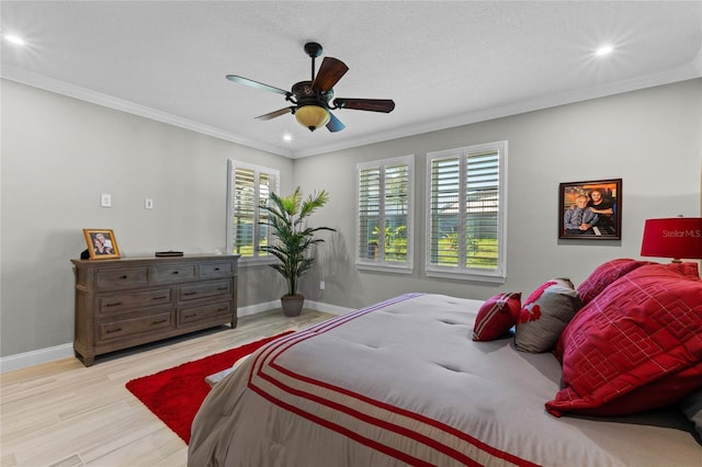 bedroom with ceiling fan, crown molding, light hardwood / wood-style floors, and a textured ceiling