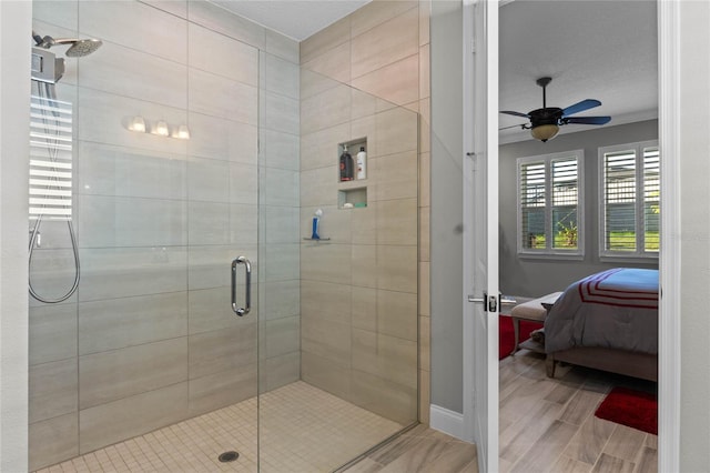 bathroom with ceiling fan, a shower with shower door, and a textured ceiling