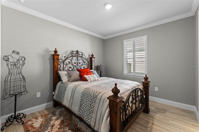 bedroom featuring a textured ceiling, light hardwood / wood-style floors, and crown molding