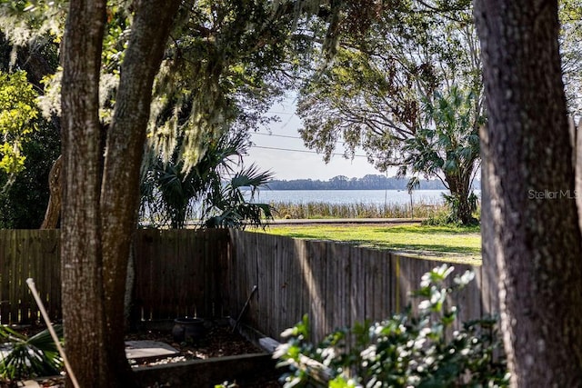 view of yard with a water view and a fenced backyard