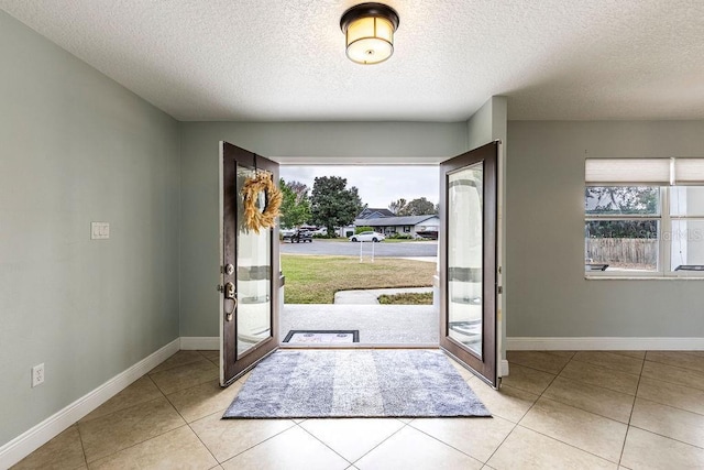 foyer entrance featuring light tile patterned floors and a textured ceiling