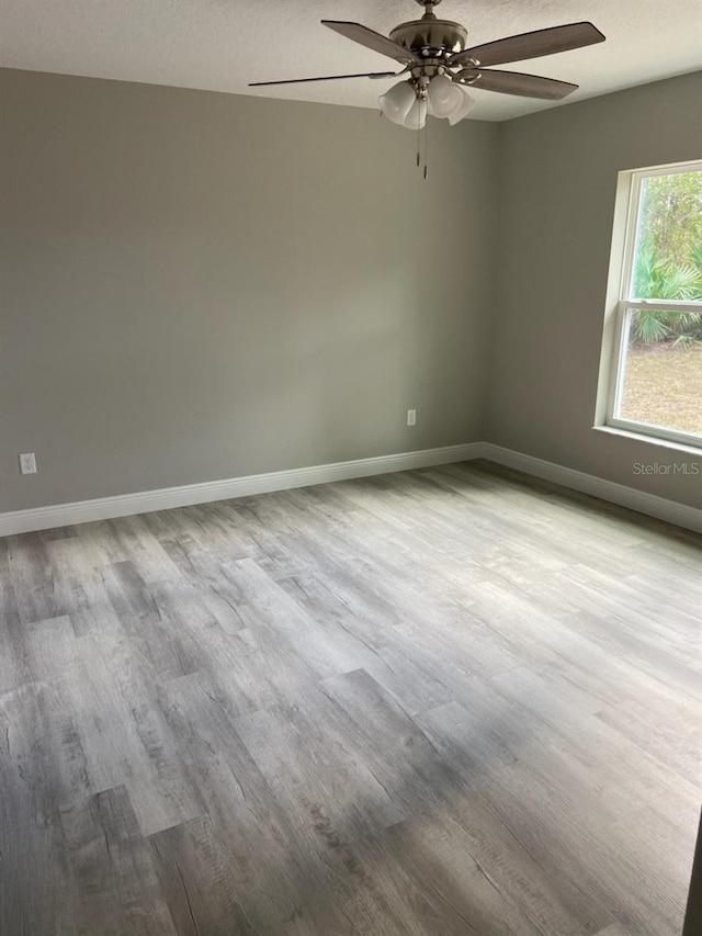 empty room with ceiling fan and light wood-type flooring