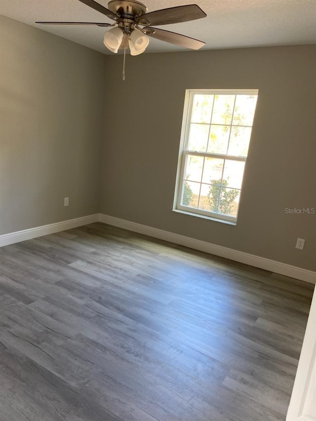 empty room with hardwood / wood-style flooring, ceiling fan, and a textured ceiling