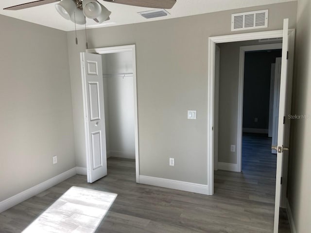 unfurnished bedroom with hardwood / wood-style flooring, ceiling fan, and a closet