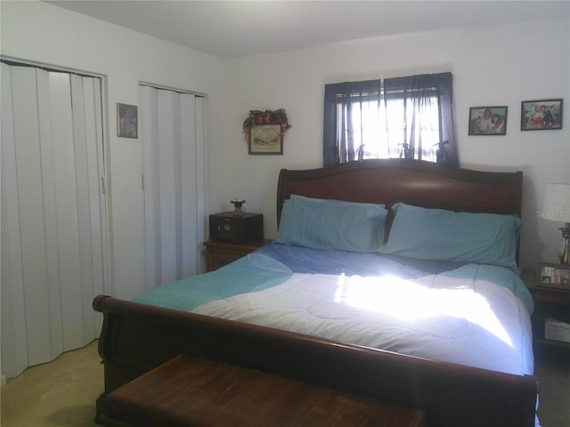 carpeted bedroom featuring two closets