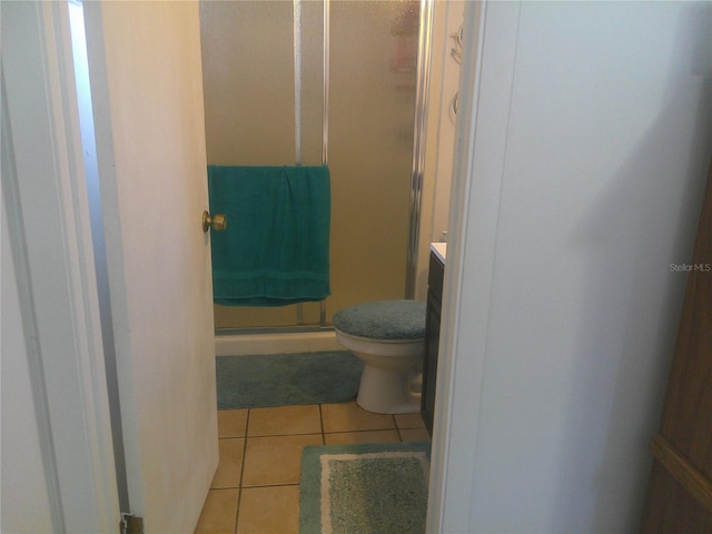 bathroom featuring tile patterned flooring, vanity, toilet, and an enclosed shower